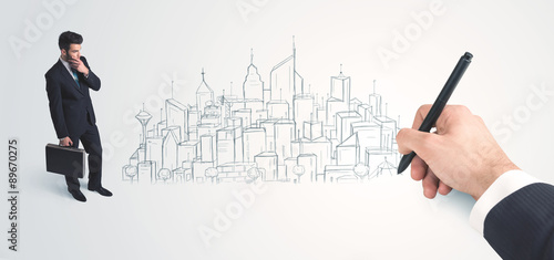 Businessman looking at hand drawn city on wall