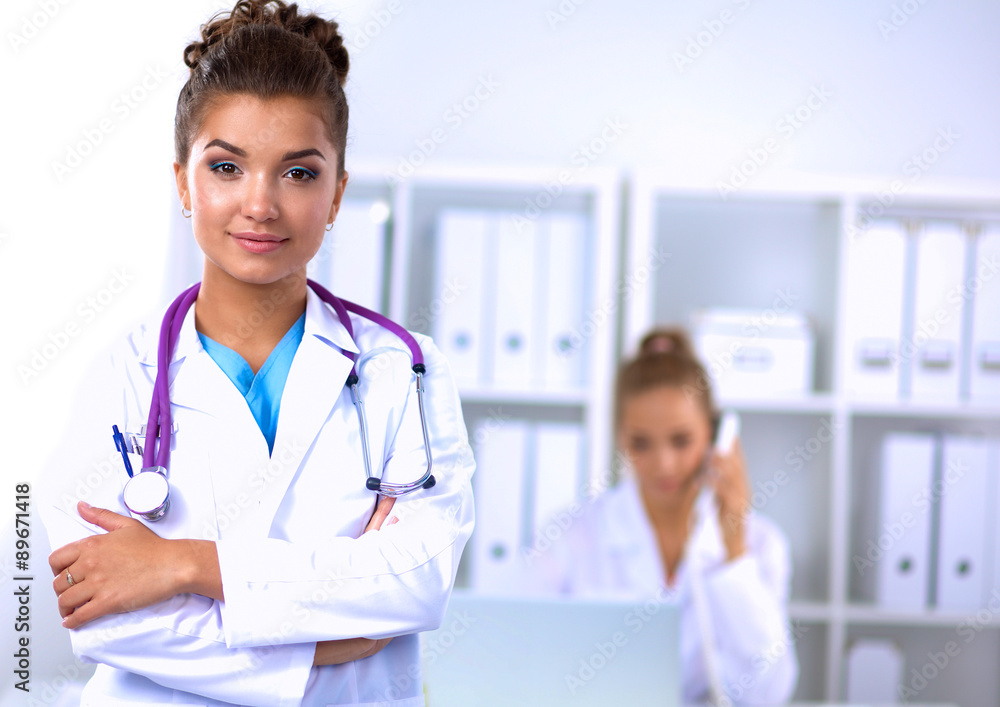 Portrait of young woman doctor with white coat standing in Portrait of young woman doctor with white coat standing in