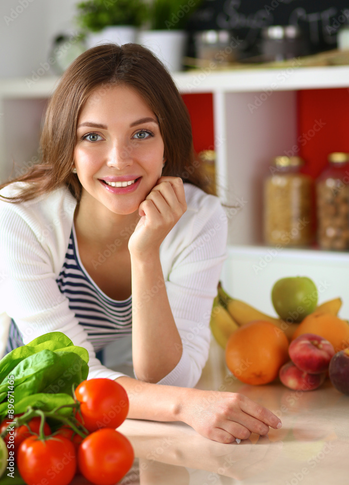 Young woman standing near desk in the kitchen Young woman standing near desk in the kitchen