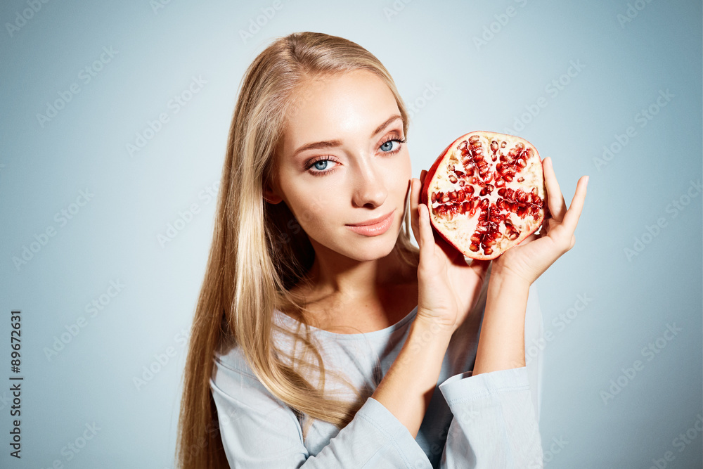 Portrait of young beautiful blonde woman with pomegranates in Portrait of young beautiful blonde woman with pomegranates in