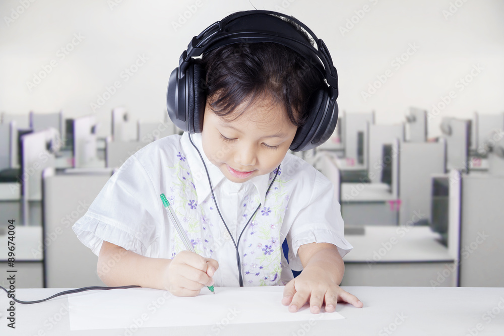 Clever student studying while wearing headphones Clever student studying while wearing headphones