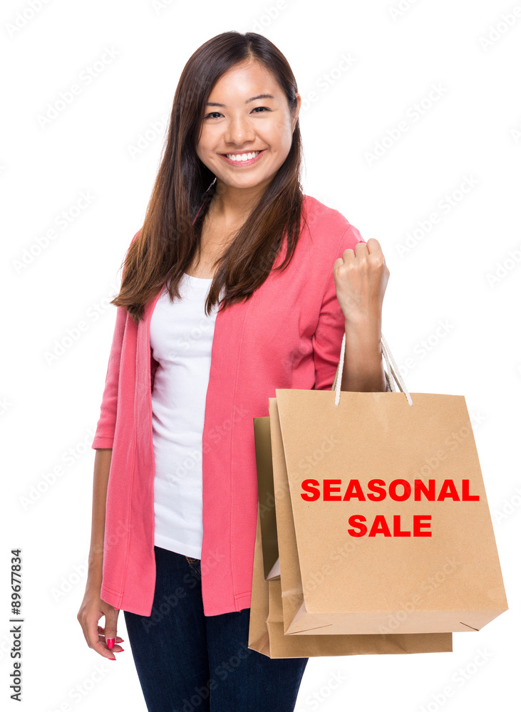 Happy woman with shopping bag and showing seasonal sale Happy woman with shopping bag and showing seasonal sale