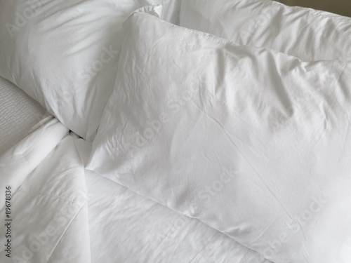 Detail of bed with set of crisp white sheets and pillows 