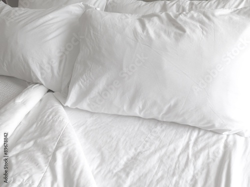 Detail of bed with set of crisp white sheets and pillows    