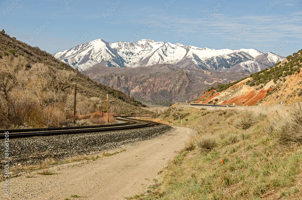 Railroad Tracks with an S-Curve and Snow-topped mountains in the distance