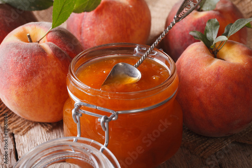 Fresh peach jam in a glass jar close up on the table. Horizontal
 photo