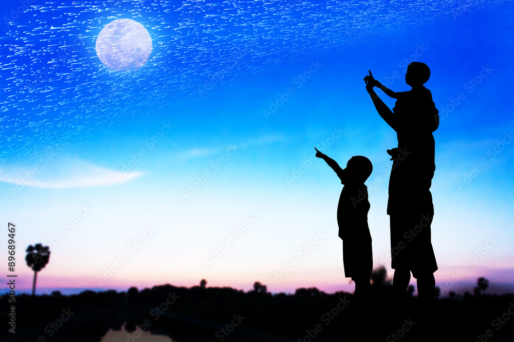 Silhouette of father use hand point his son look at full moon on Silhouette of father use hand point his son look at full moon on