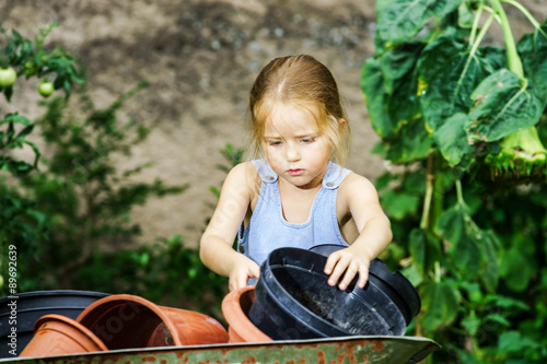 Cute little girl helping her mother in the backyard photo