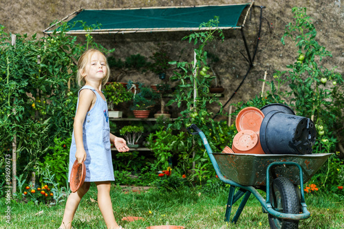 Cute little girl helping her mother in the backyard photo