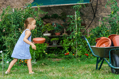 Cute little girl helping her mother in the backyard photo