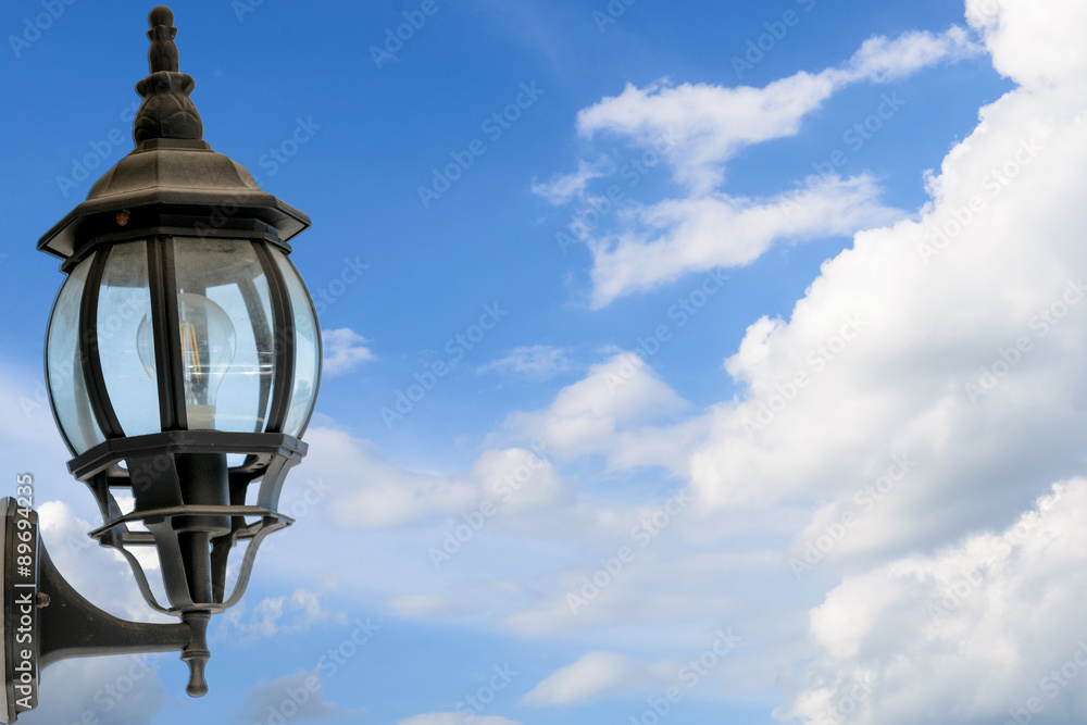 Vintage wall lamp on background blue sky with clouds in the clear day.