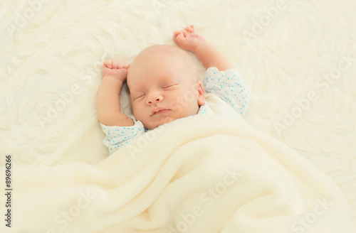 Sweet sleep infant lying on the bed at home