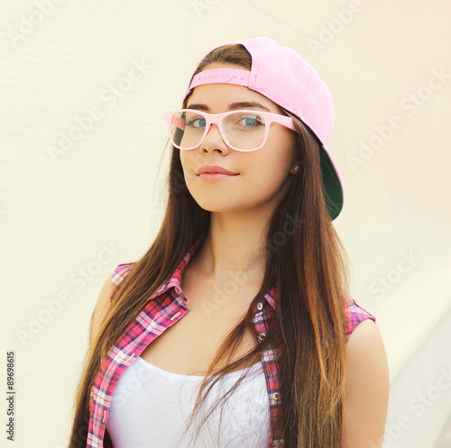 Portrait of pretty young cool girl wearing a pink clothes and gl