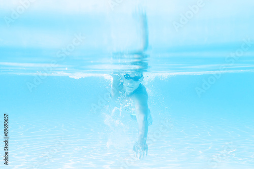 young man swimming the front crawl style in a pool