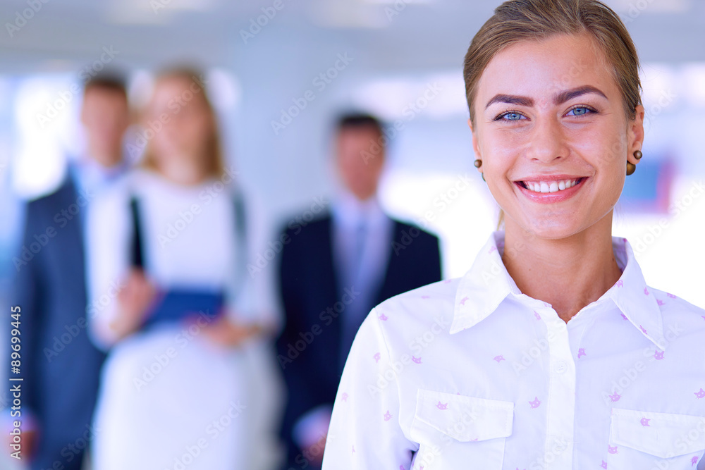 Smiling successful business team standing in office Smiling successful business team standing in office