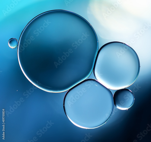 Abstract background, blue oil droplets on water surface.