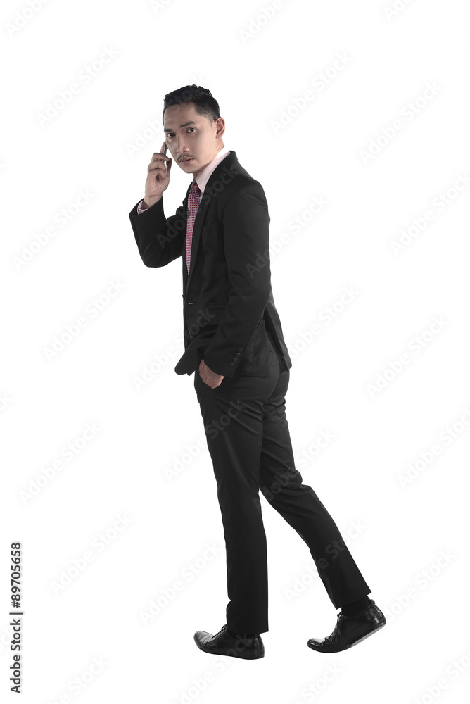 Business man walking while talking via cellphone Business man walking while talking via cellphone