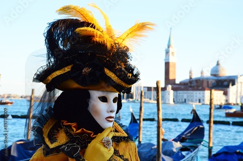 Yellow masked person and gondola background at the Carnival of Venice © damaisin1979