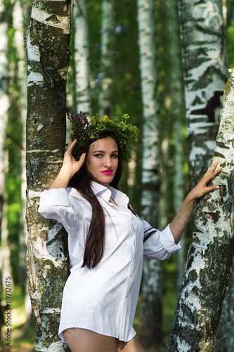 beautiful woman in shirt standing near the birches