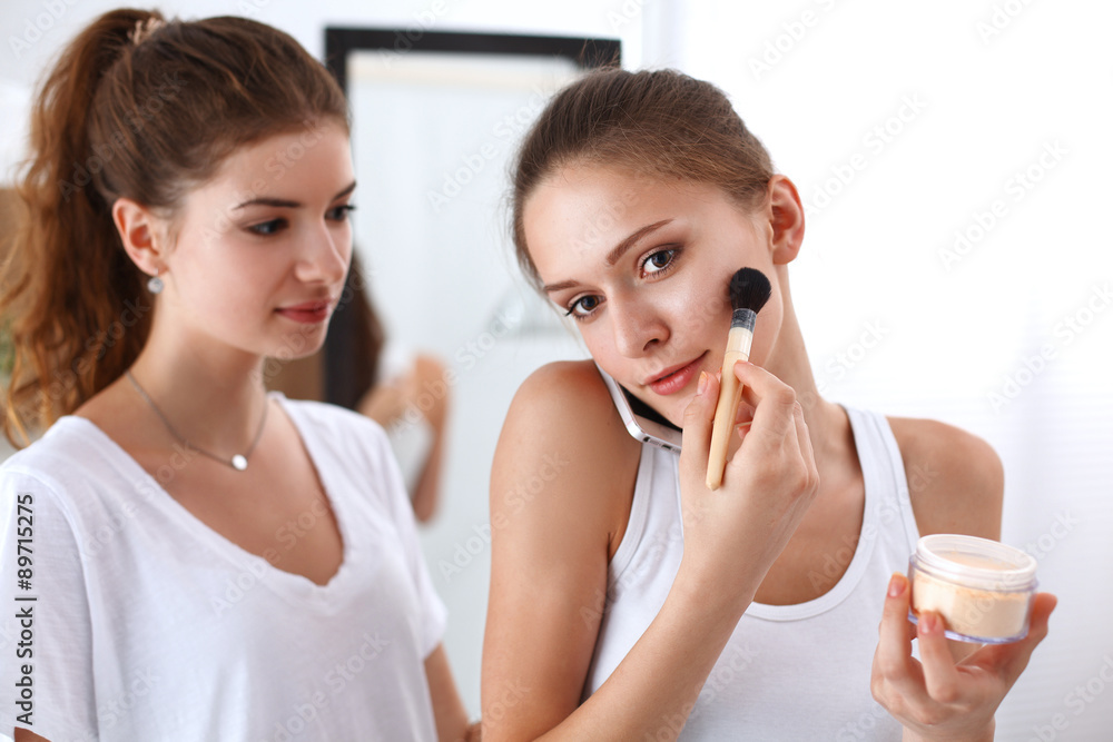 Beautiful girls looking in the mirror and applying cosmetic with Beautiful girls looking in the mirror and applying cosmetic with