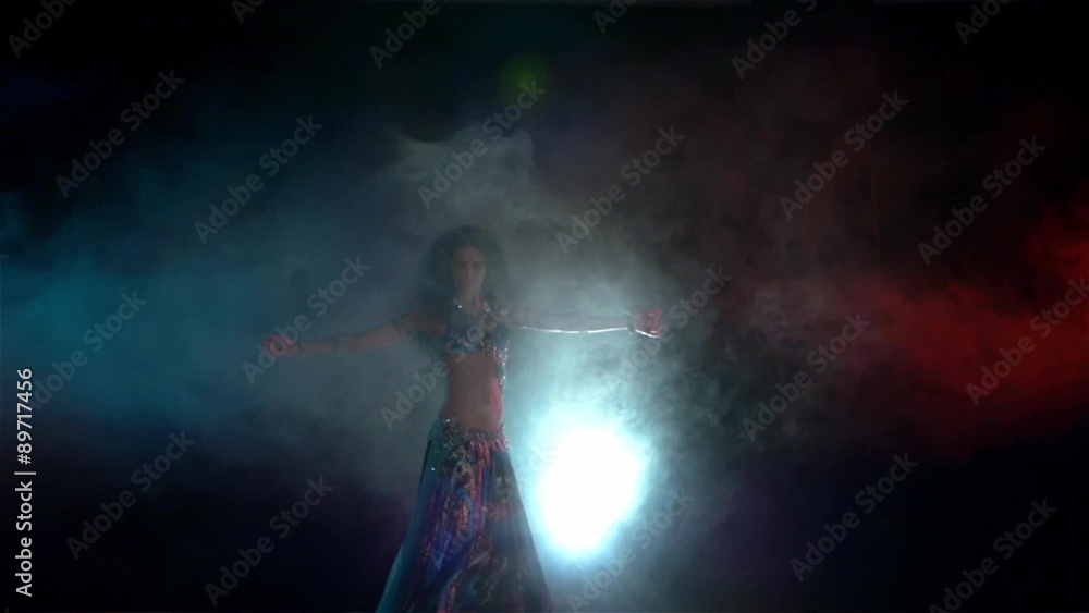Movements of beautiful woman finishing belly dance in blue dress Movements of beautiful woman finishing belly dance in blue dress