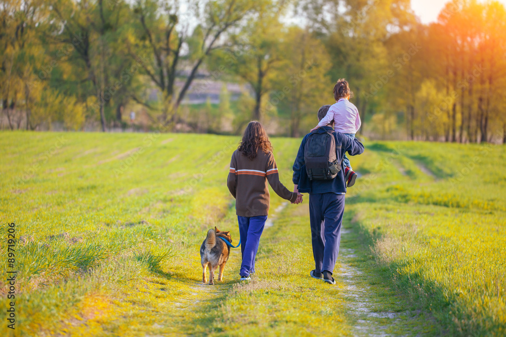 Fototapeta premium Happy family walking with dog