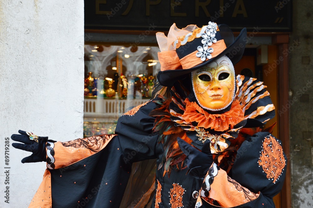 Orange mask costume indicating a pub during the Carnival in Venice, Italy