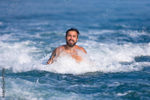 Mann wird im Wasser vom Boot gezogen © nakedking