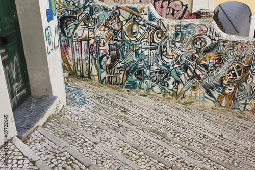 Graffiti on Calcada do Lavra street in Lisbon, Portugal, along a stairway with a door