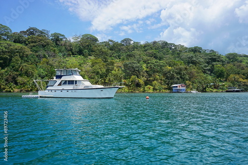 Yacht on mooring buoy with lush tropical coast © dam