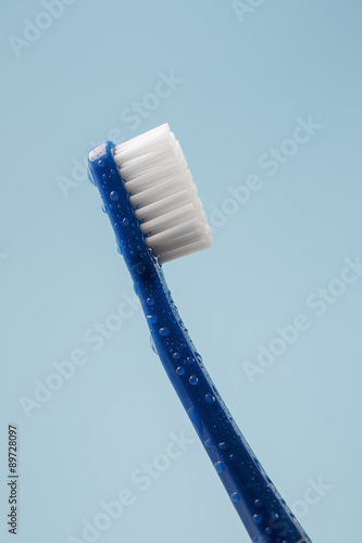 Blue toothbrush covered with water drops