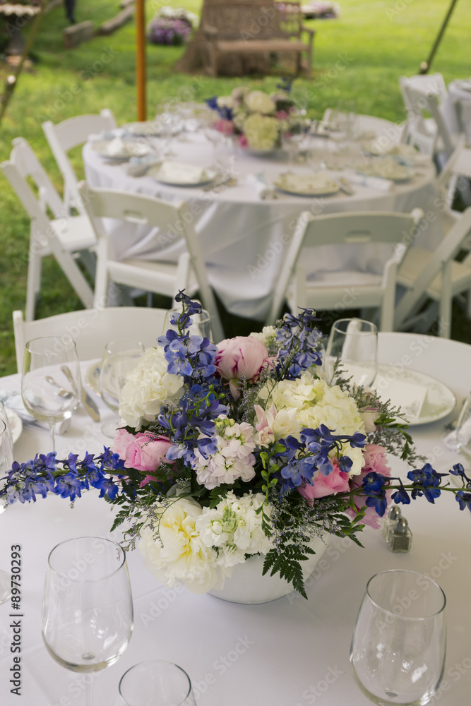 Flower arrangements on tables with glasses.