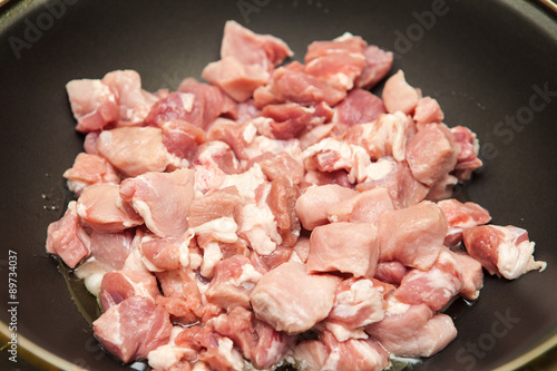 meat cut into pieces fried in a pan