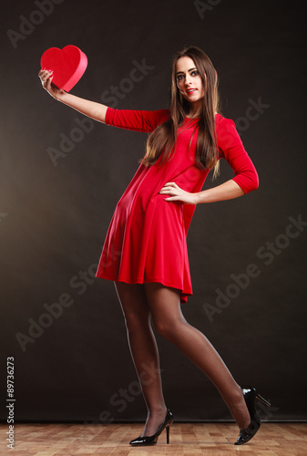 Woman holding heart in red dress. © Voyagerix