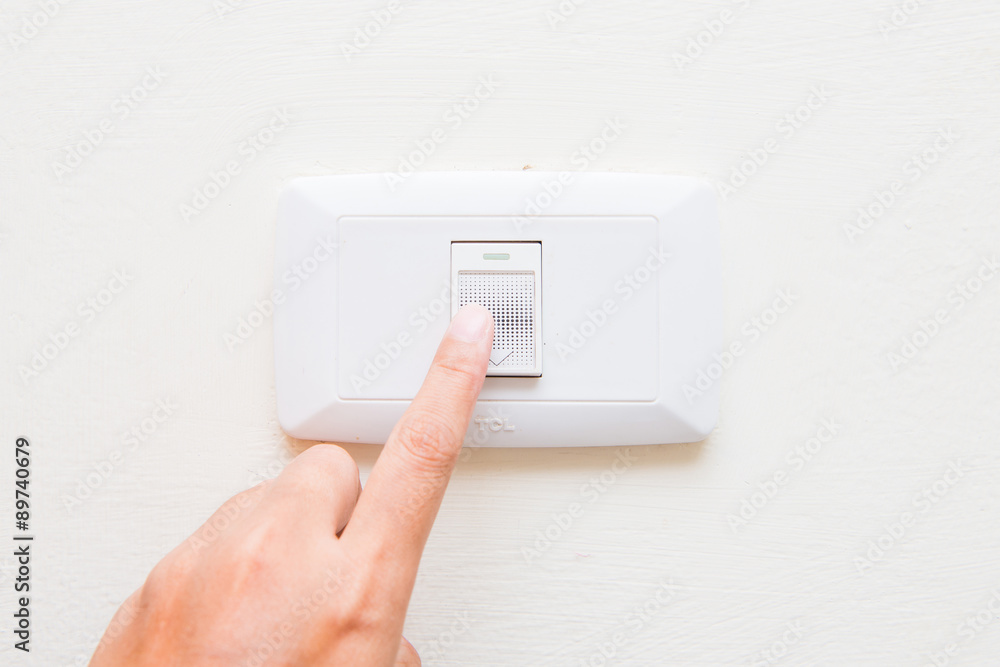hand pressing light power switch on wall hand pressing light power switch on wall