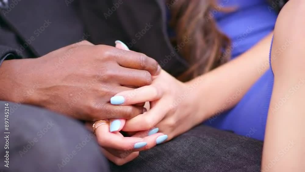 A couple holding hands while sitting on a bench A couple holding hands while sitting on a bench