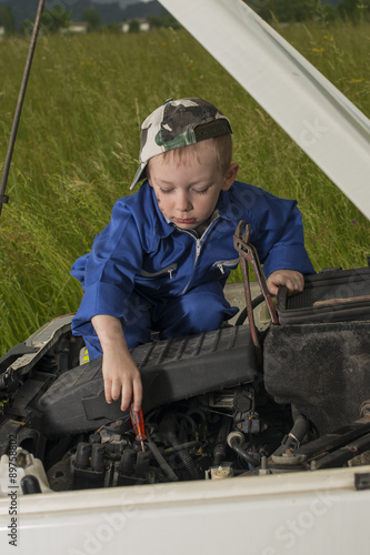 Obraz na płótnie Meccanico bambino al lavoro su motore auto w salonie