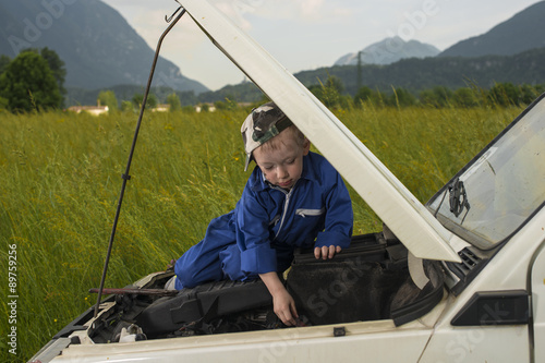 Obraz na płótnie Bambino meccanico al lavoro su motore w salonie