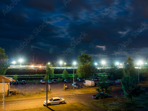 car parking at night with street lights and dark clouds