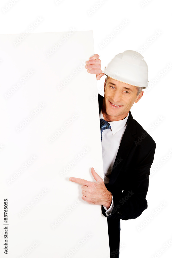 Businessman with hard hat holding empty banner Businessman with hard hat holding empty banner