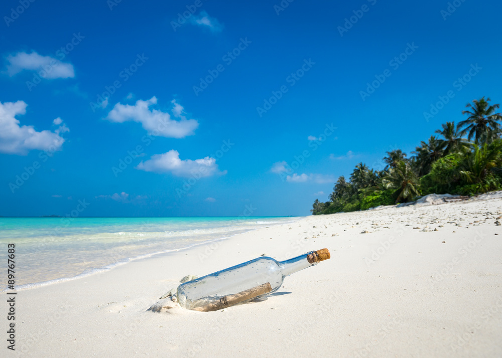 Fotografie Message in a bottle washed ashore on a tropical beach.
