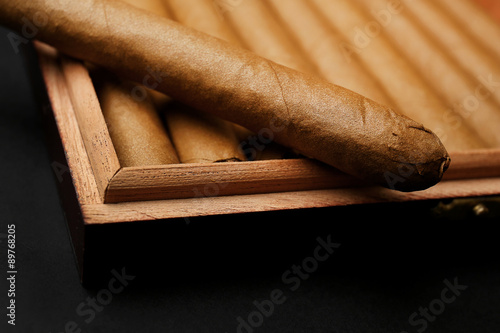 Foto Cigars in box on table, closeup