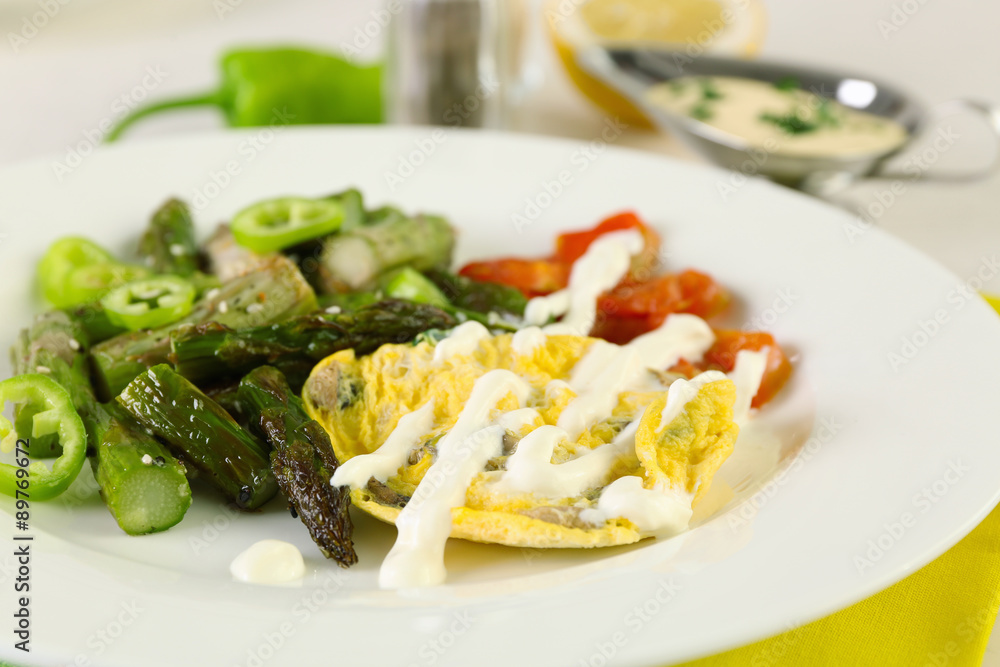 Roasted asparagus with fried egg on plate on table, close-up Roasted asparagus with fried egg on plate on table, close-up