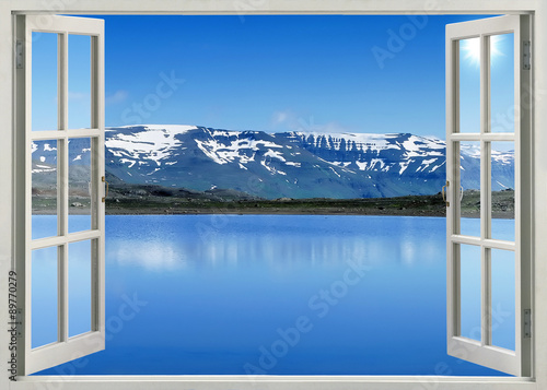Open window panoramic view to snow mountains and lake