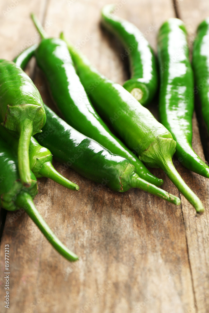 Green hot peppers on wooden table close up Green hot peppers on wooden table close up