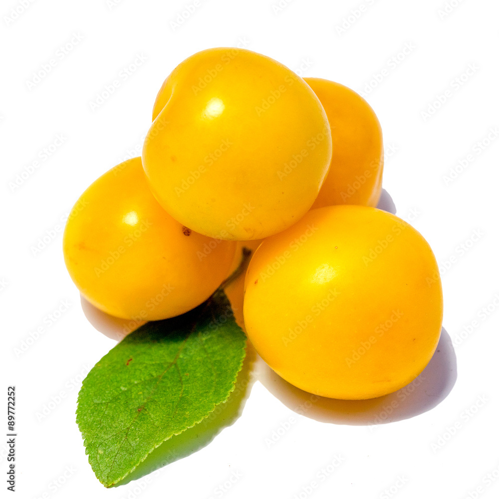 Four yellow plums with leaf isolated on white background Four yellow plums with leaf isolated on white background