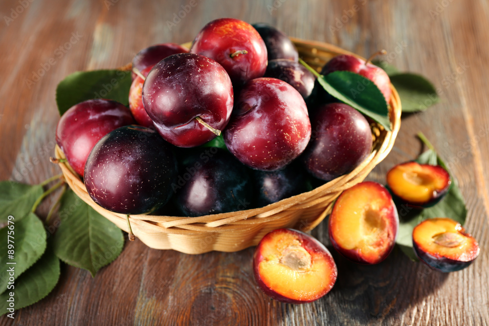 Ripe plums in bowl on wooden background Ripe plums in bowl on wooden background