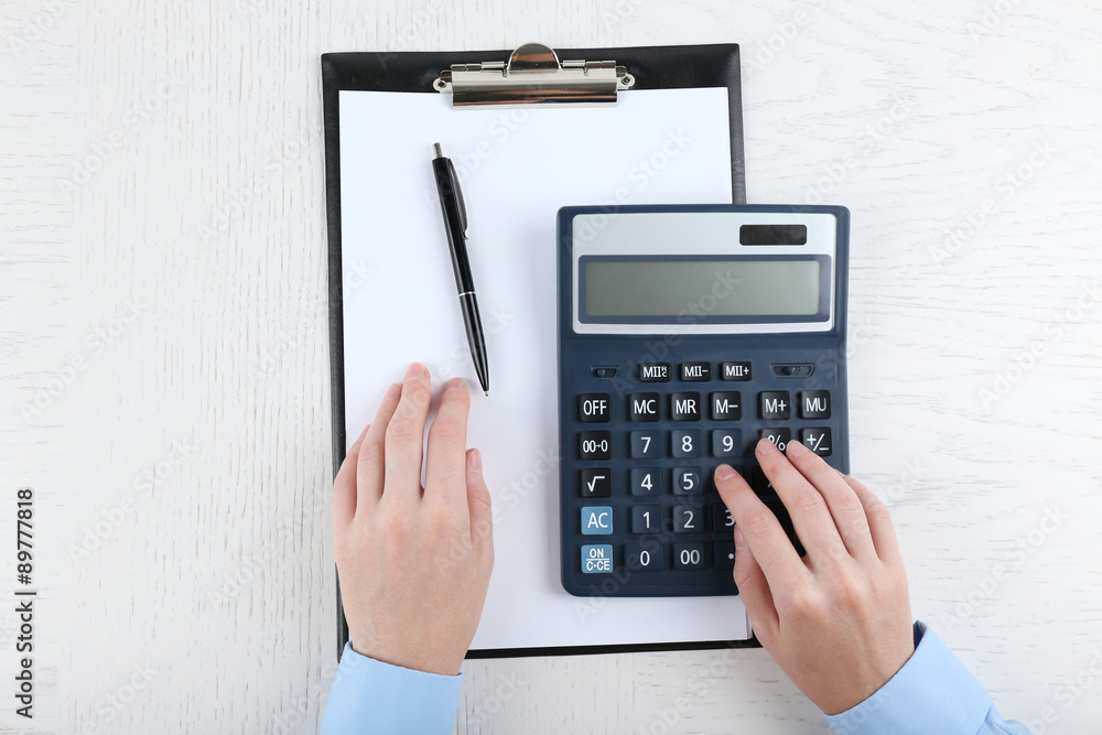 Hands working in the office with documents and calculator on white table Hands working in the office with documents and calculator on white table