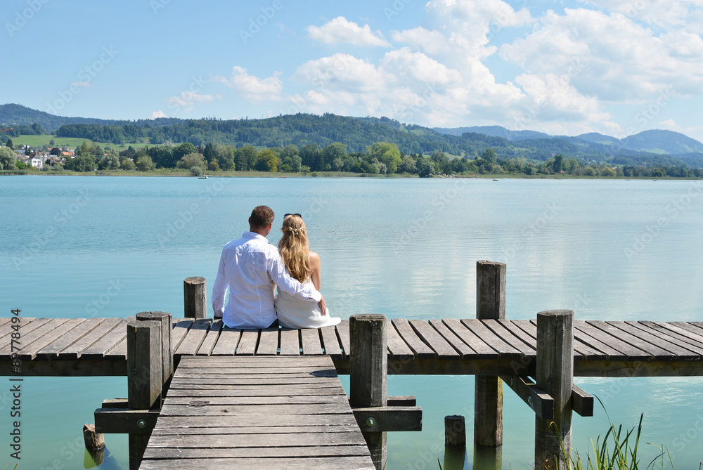 A couple on the wooden jetty at the lake. Switzerland