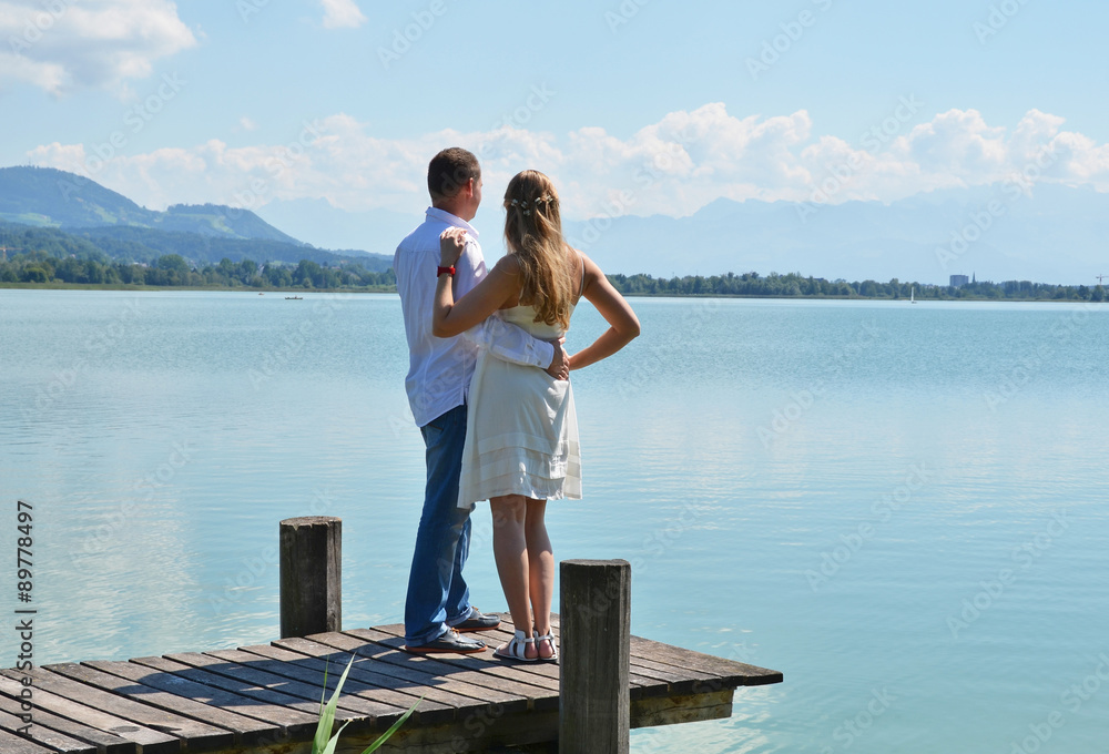 A couple on the wooden jetty at the lake. Switzerland